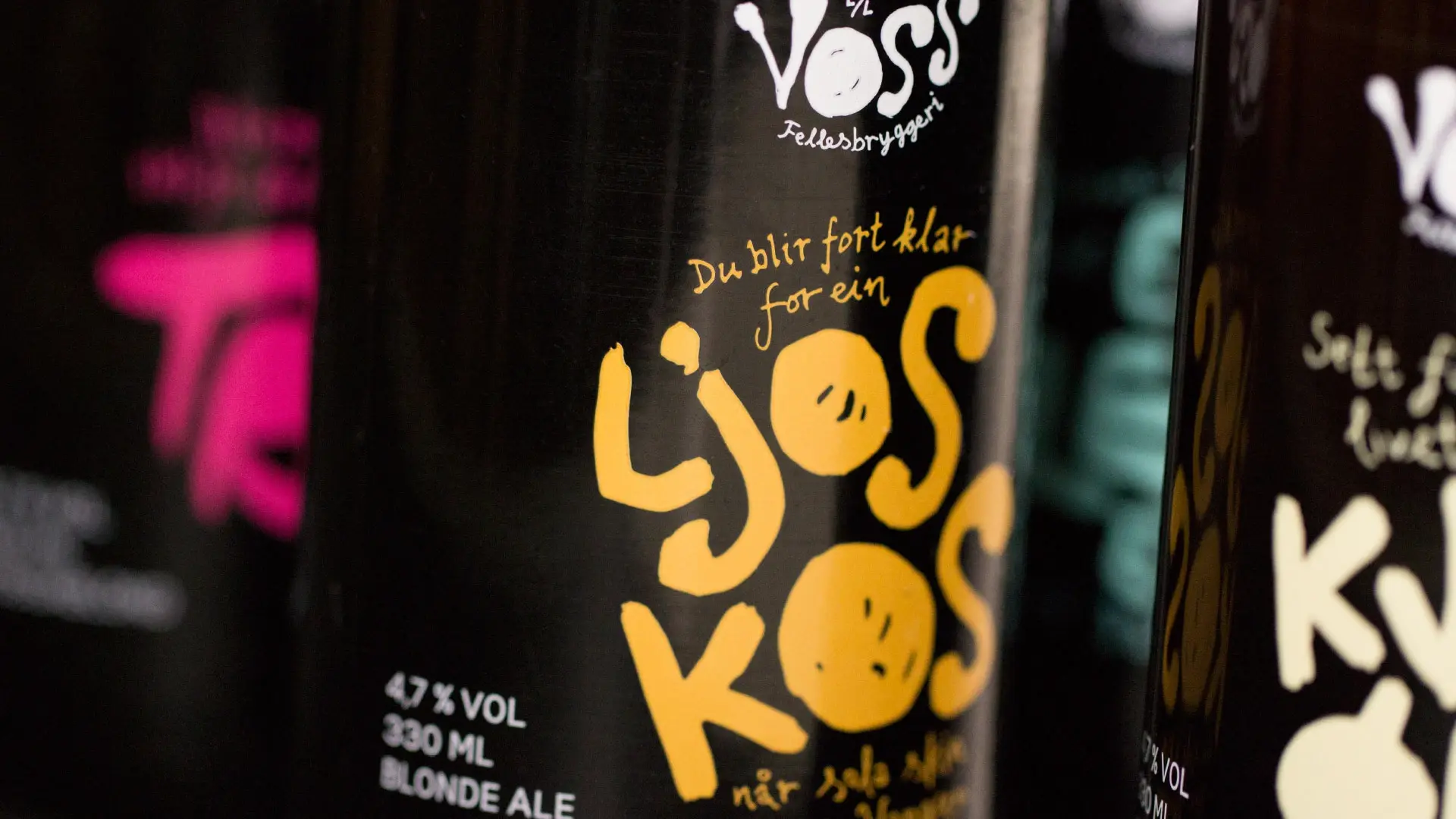 Nærbilde av en Voss Fellesbryggeri-flaske med håndtegnet gul typografi: «Du blir fort klar for ein Ljos Kos»