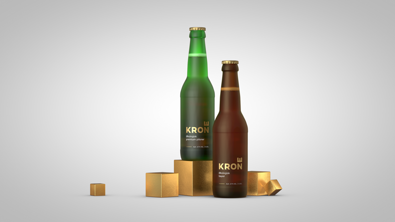 Two Krone bottles, a green pilsner and a brown bayer, on gold cubes against a light background